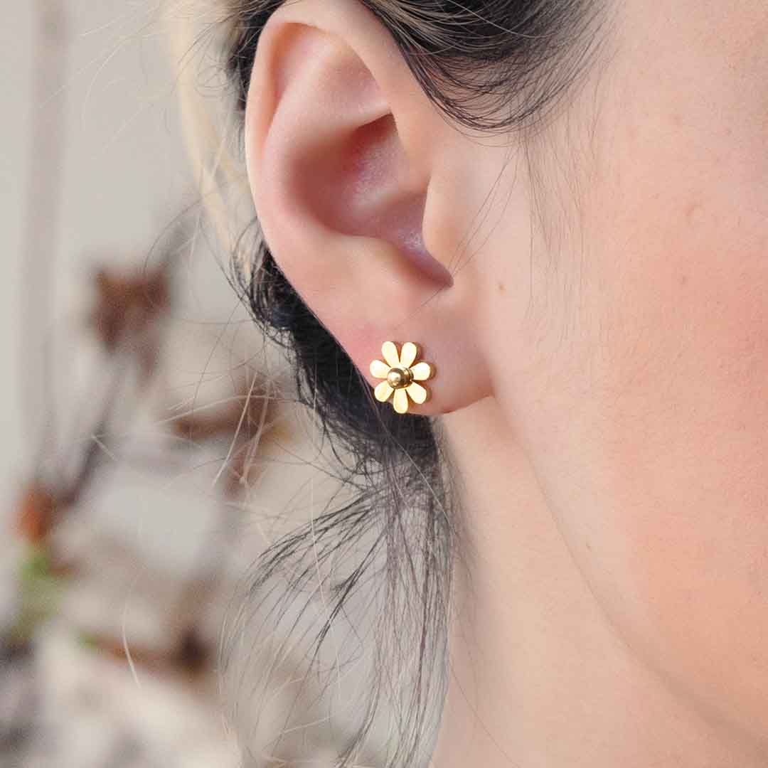 model wearing daisy stud earrings gold