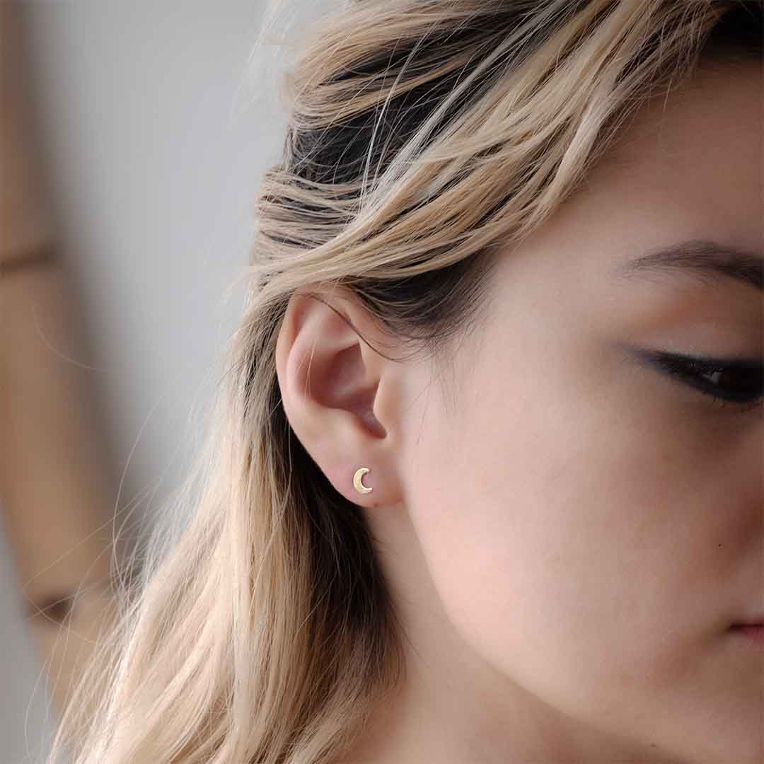 model wearing new moon stud earrings gold