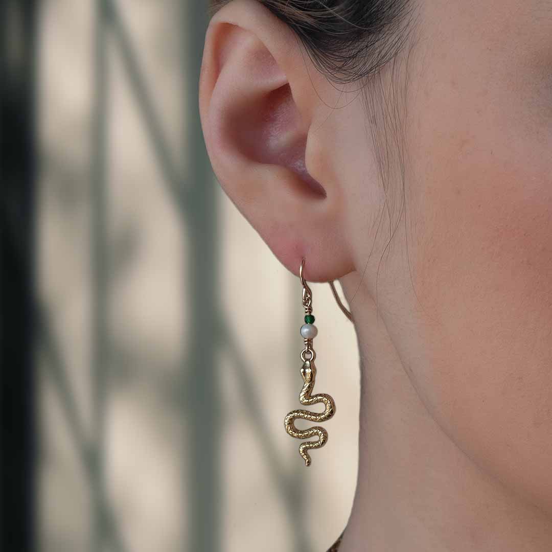 model wearing serpent drop earrings gold pearl